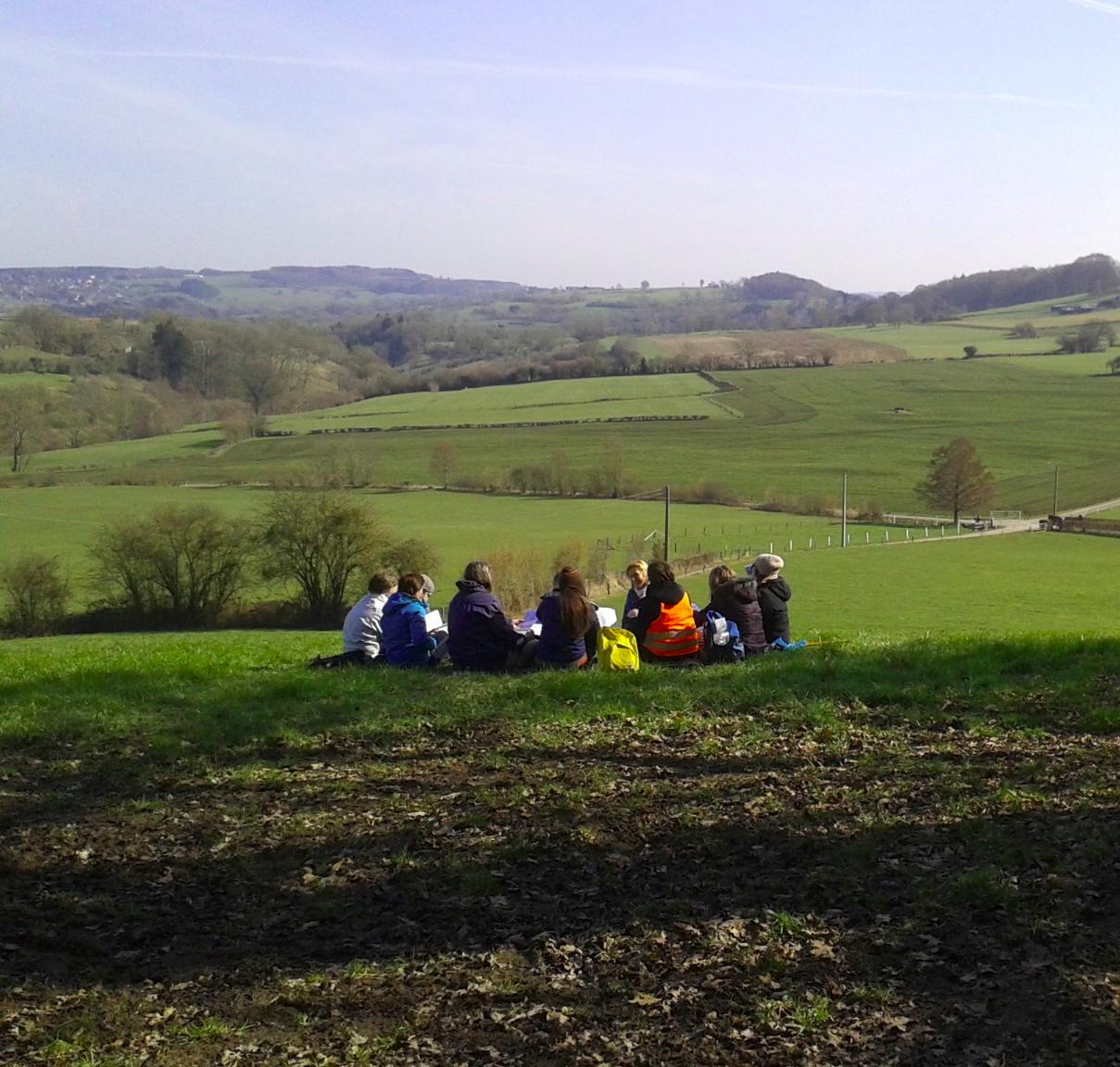 Photo de la marche des mères, groupe de femme assises dans un paysage vallonné