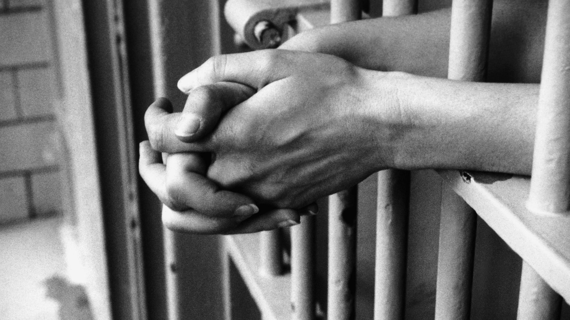 photo des mains d'une personne en prison.