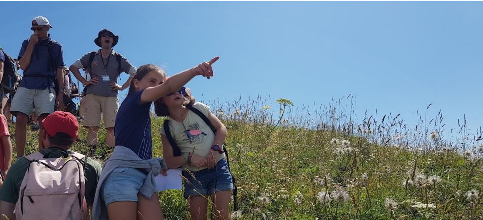 Bannière pour les vacances Jonas-en-Ardenne 2025. C'est une photo représentant un groupe de jeunes en montagne.