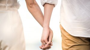 Photo d'un couple se tenant par la main. On ne voit que les mains.